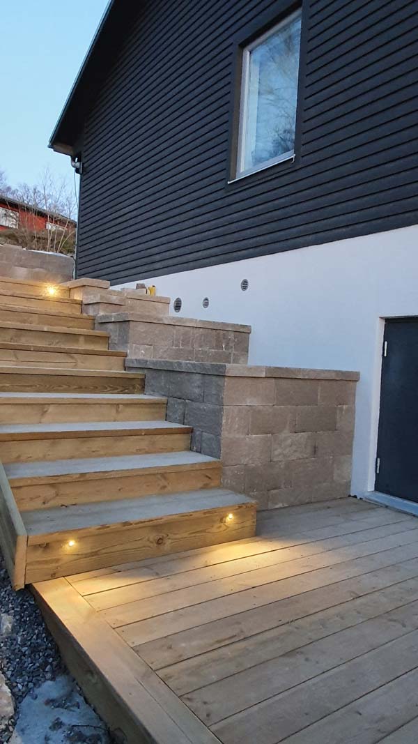 Stödmur som är platsbyggd bredvid trätrappa.