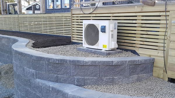 Kurvad stödmur byggd runt altan.